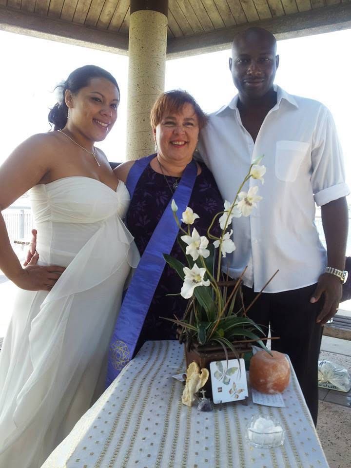 Rev. Christine smiling with a bride and groom at their waterfront ceremony